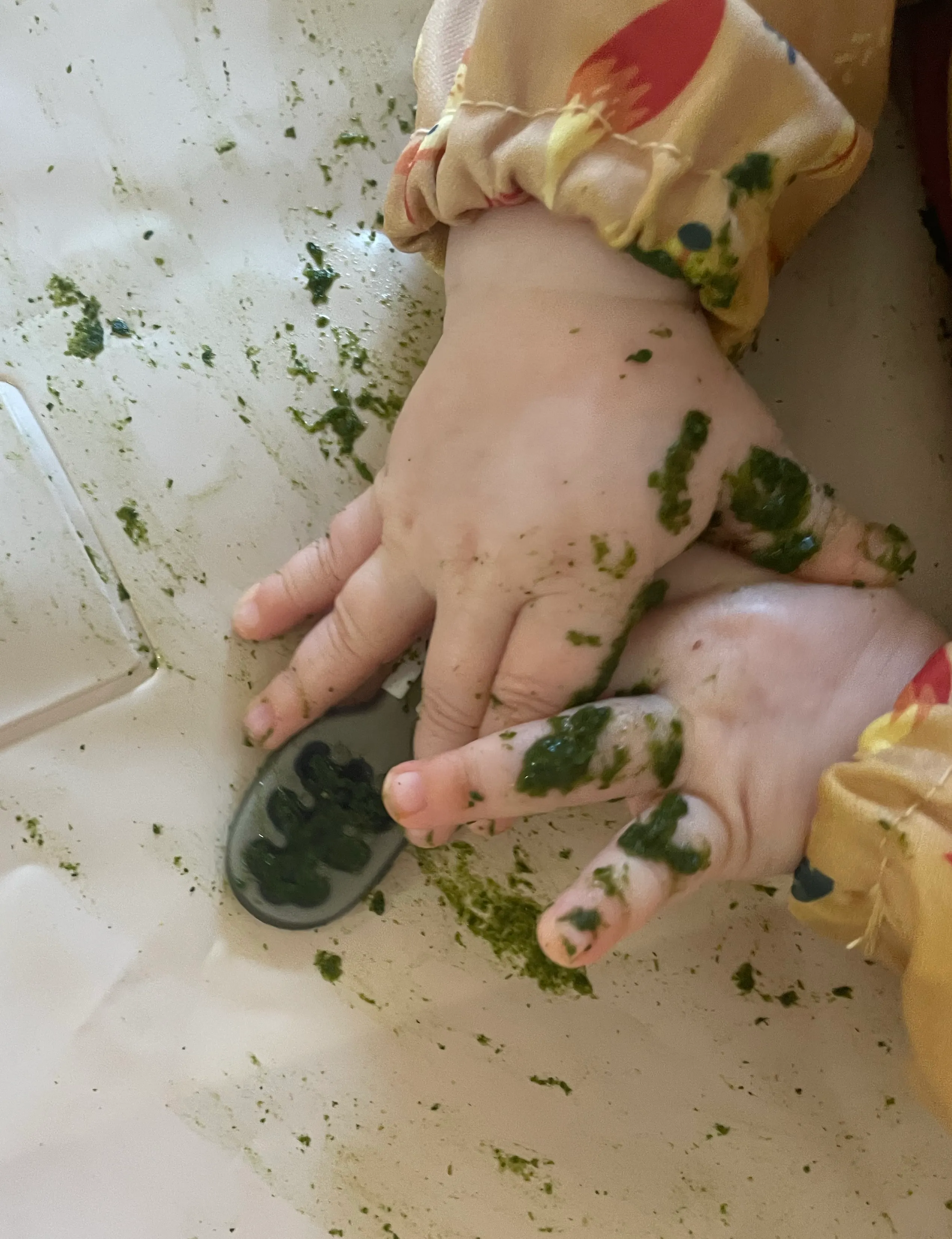 Mains d’un bébé découvrant les aliments pendant son repas